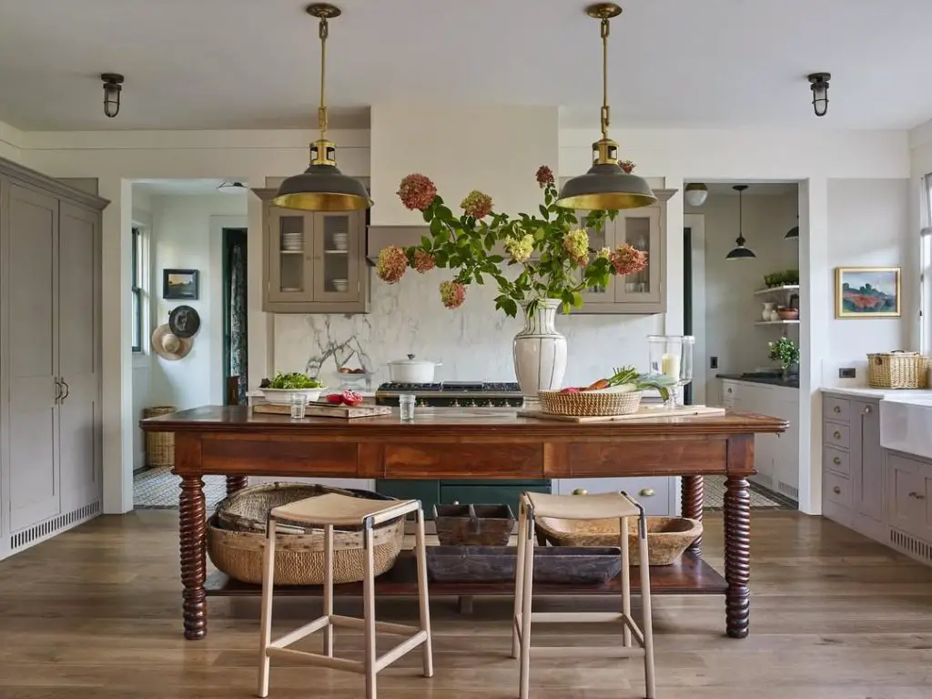 Gray kitchen with wooden dining table and brass pendants