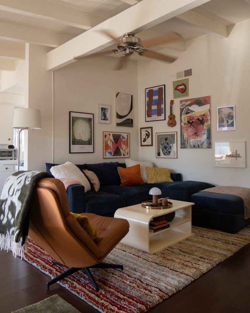 Living room with gallery wall, navy sofa, and eclectic art collection