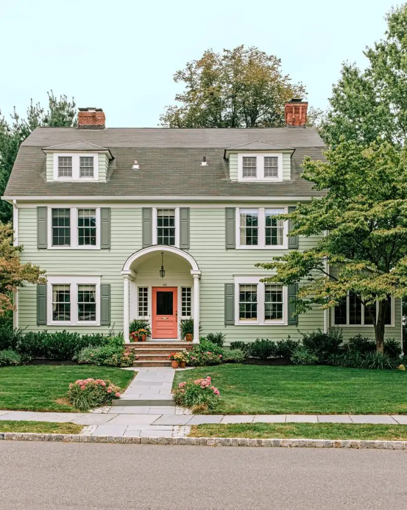 Green colonial house with coral door entrance