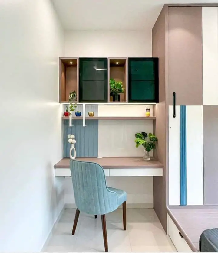 Colorful study nook with green cabinets and blue chair