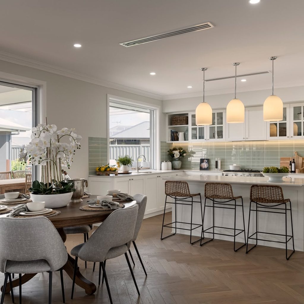 Traditional white kitchen with green subway tiles and pendant lights