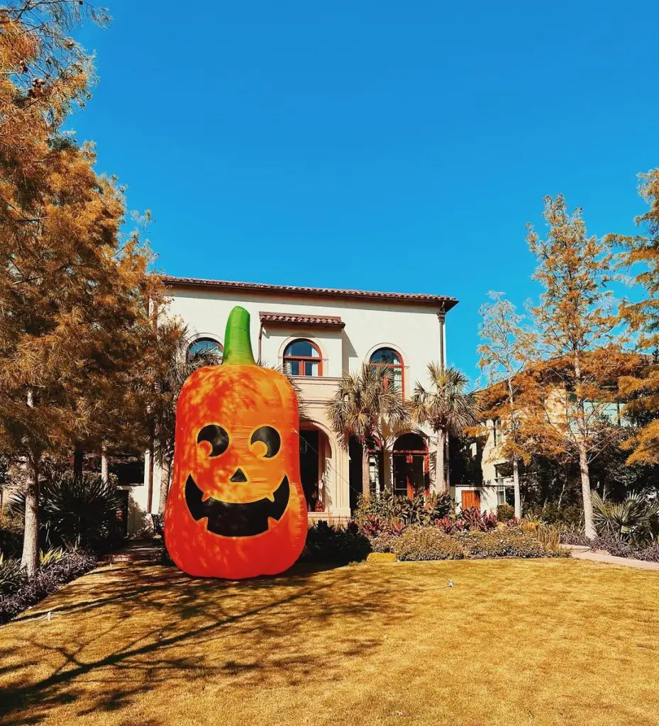 Large inflatable Halloween pumpkin decoration on front lawn