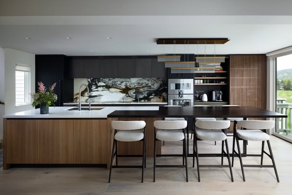 Contemporary kitchen with black cabinets, marble backsplash, wood island, modern lighting