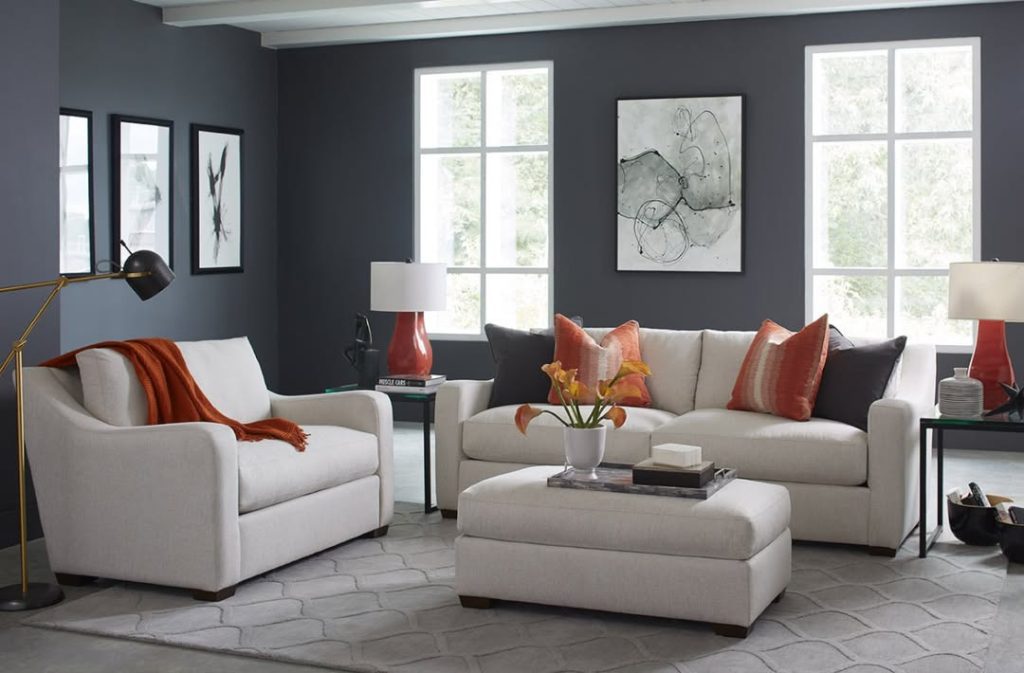 Gray sofa against dark walls with colorful pillows and natural light
