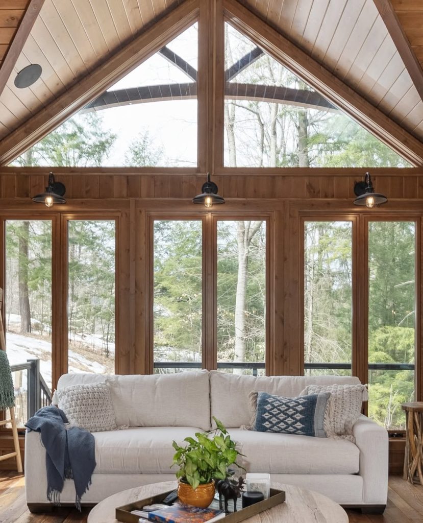White sofa under triangular windows with wooden beam ceiling