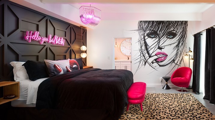 Modern bedroom with neon sign geometric headboard and leopard rug