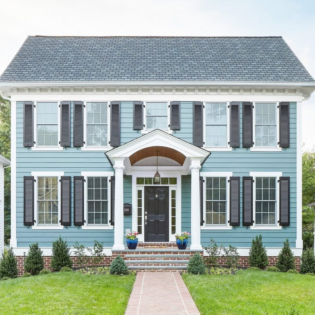 Blue colonial house with black shutters portico