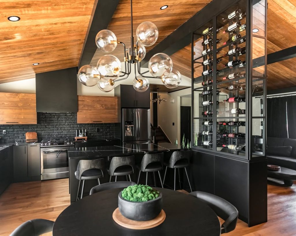 Modern kitchen with exposed beams, glass wine storage, and pendant lighting