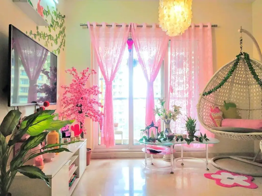 Pink living room with hanging chair and tropical plants