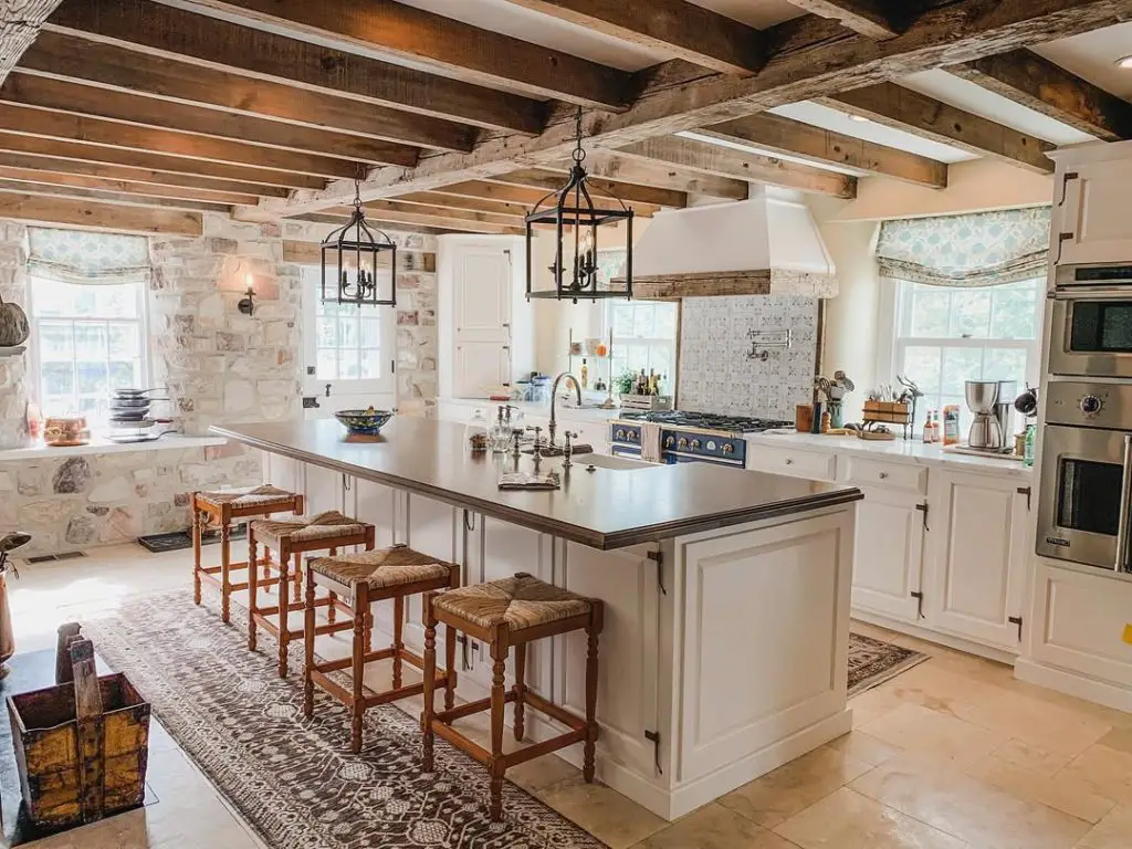 Rustic kitchen with stone walls, exposed beams, lantern pendants