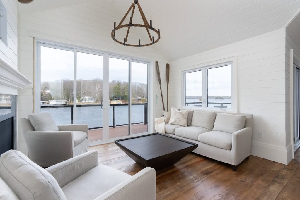 Modern white living room with large waterfront windows