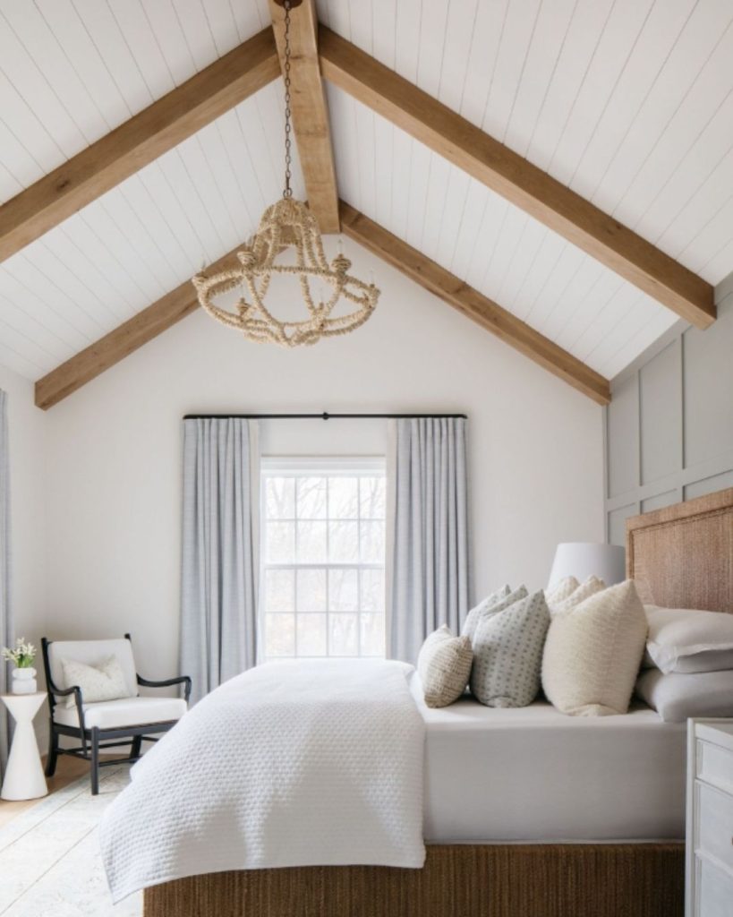 White farmhouse bedroom with exposed beams and rope chandelier