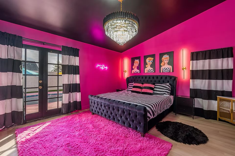 Pink bedroom with black tufted bed and crystal chandelier