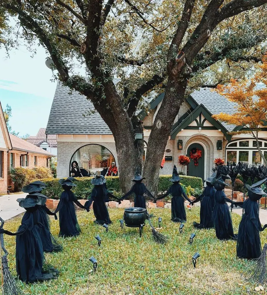 Halloween witch circle display with cauldron on front lawn