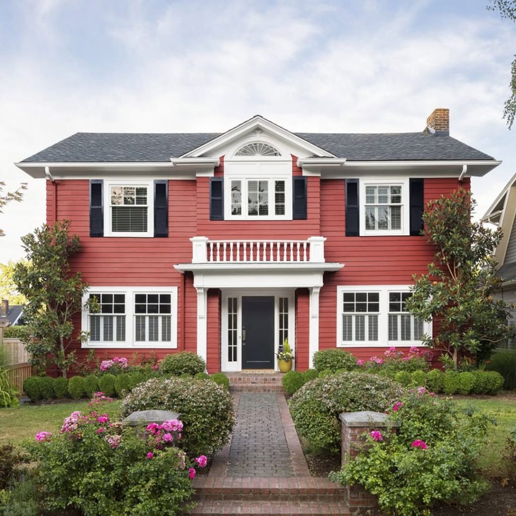 Red colonial house with white porch balustrade
