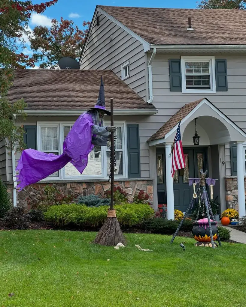 Purple witch flying on broomstick across front yard landscape