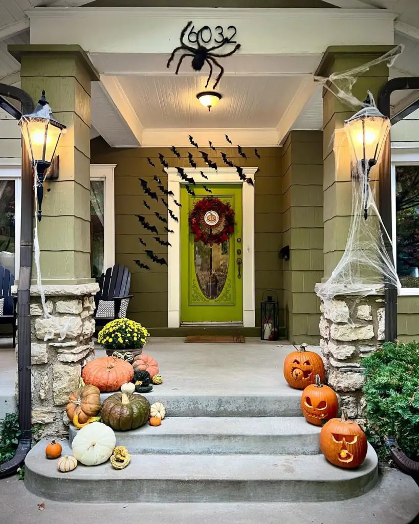 Halloween porch decorated with giant spider bats and pumpkins