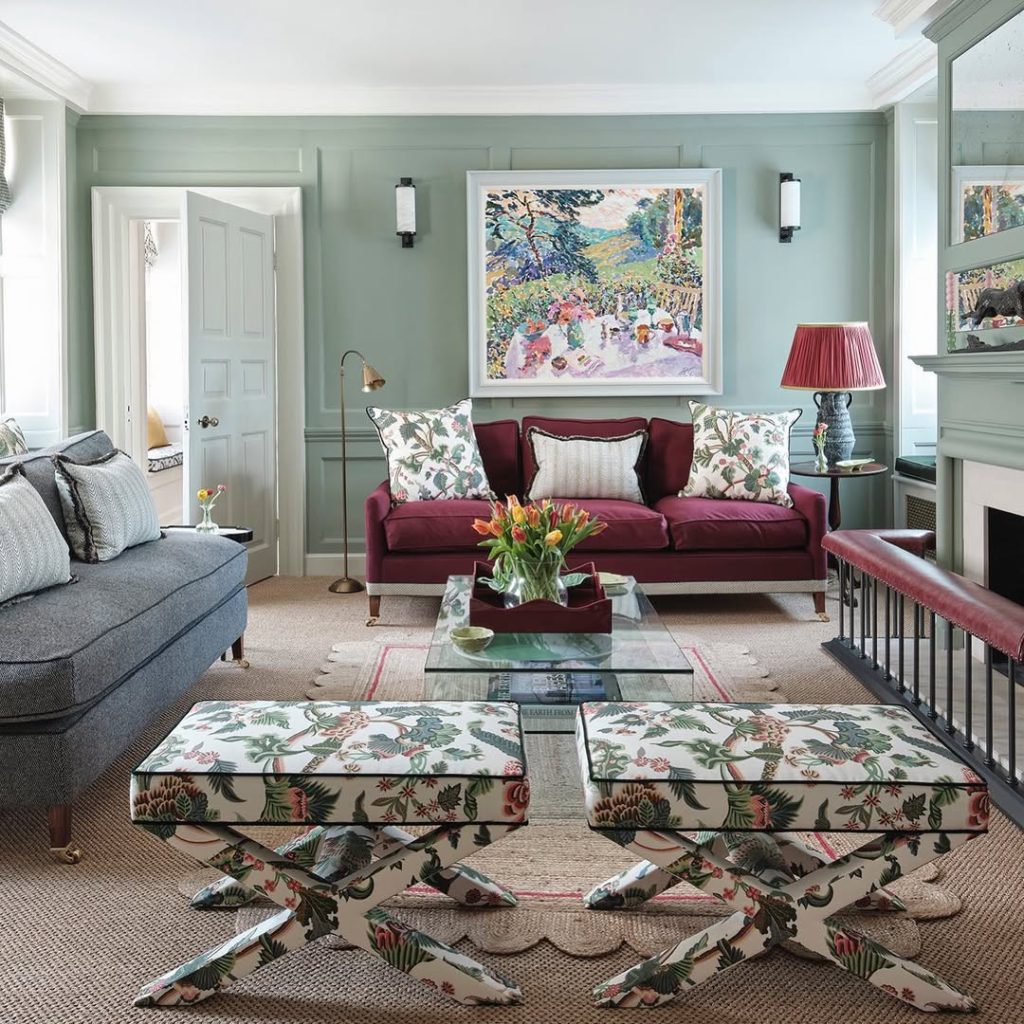 Sage green living room with burgundy sofa and botanical accents