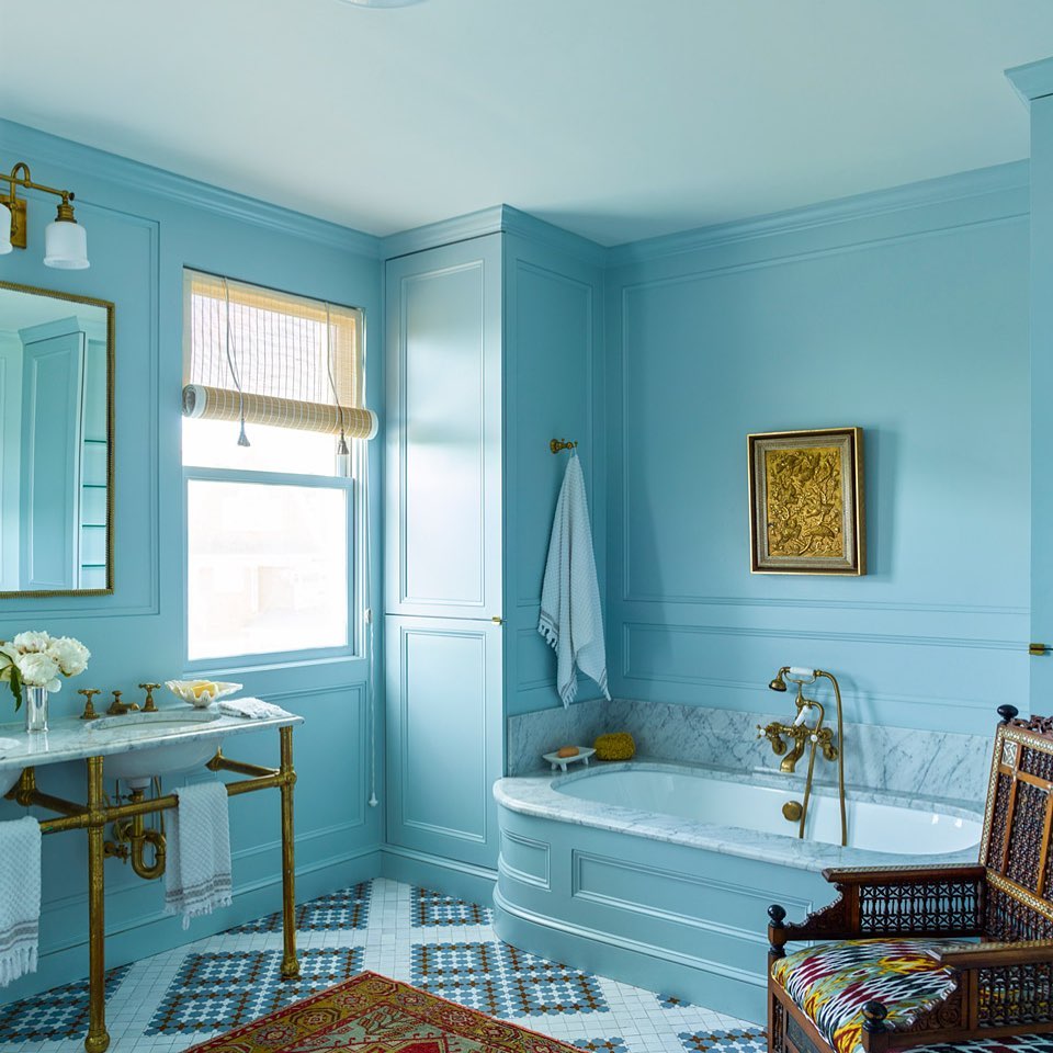 Classic blue bathroom with brass fixtures and marble details