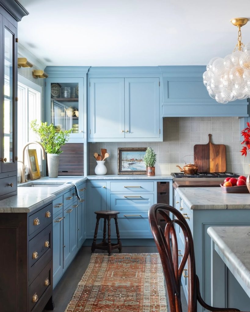 Elegant blue kitchen with crystal chandelier and marble counters