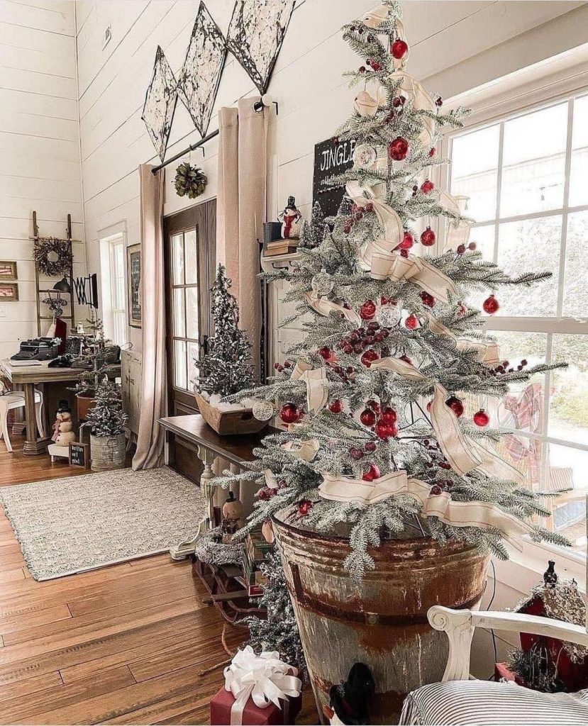 Farmhouse Christmas tree displayed in vintage washstand with rustic wall decor