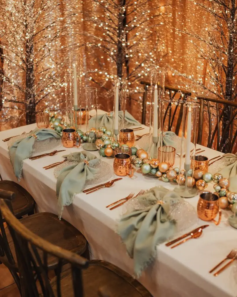 Warm copper Christmas table with sage napkins candles ornaments