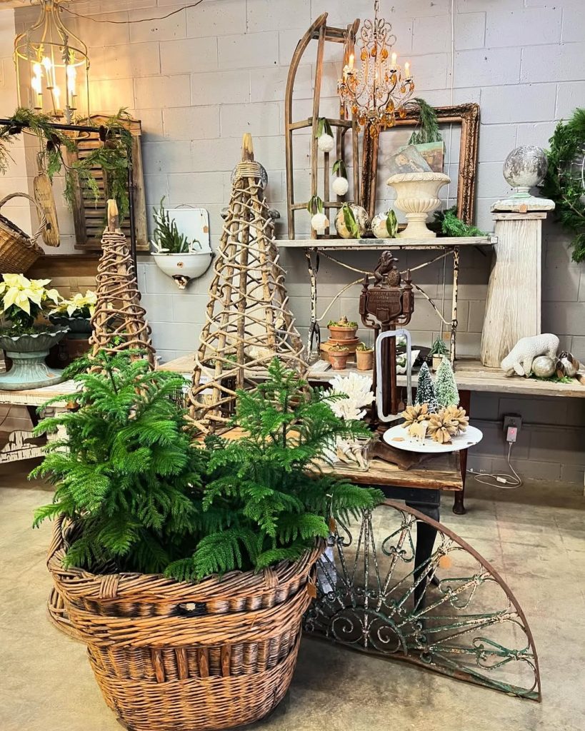 Garden shop display with baskets, plants, vintage scales, wooden trellises, holiday greenery