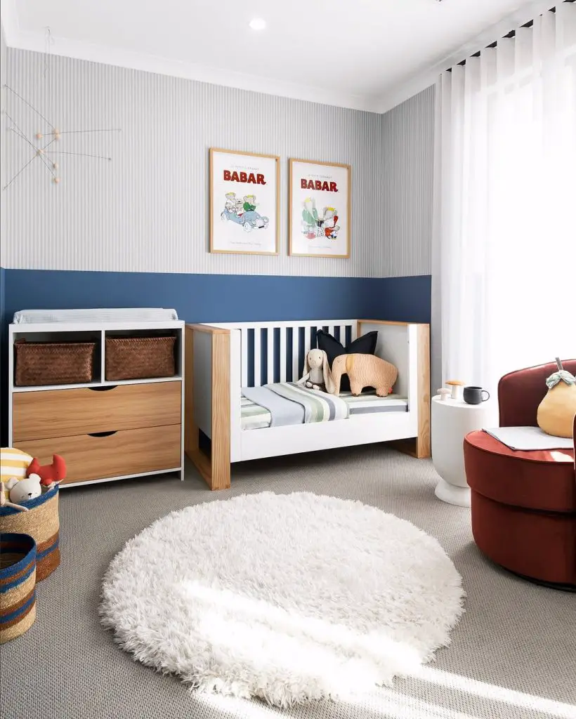 Striped nursery with toddler bed and character wall art.