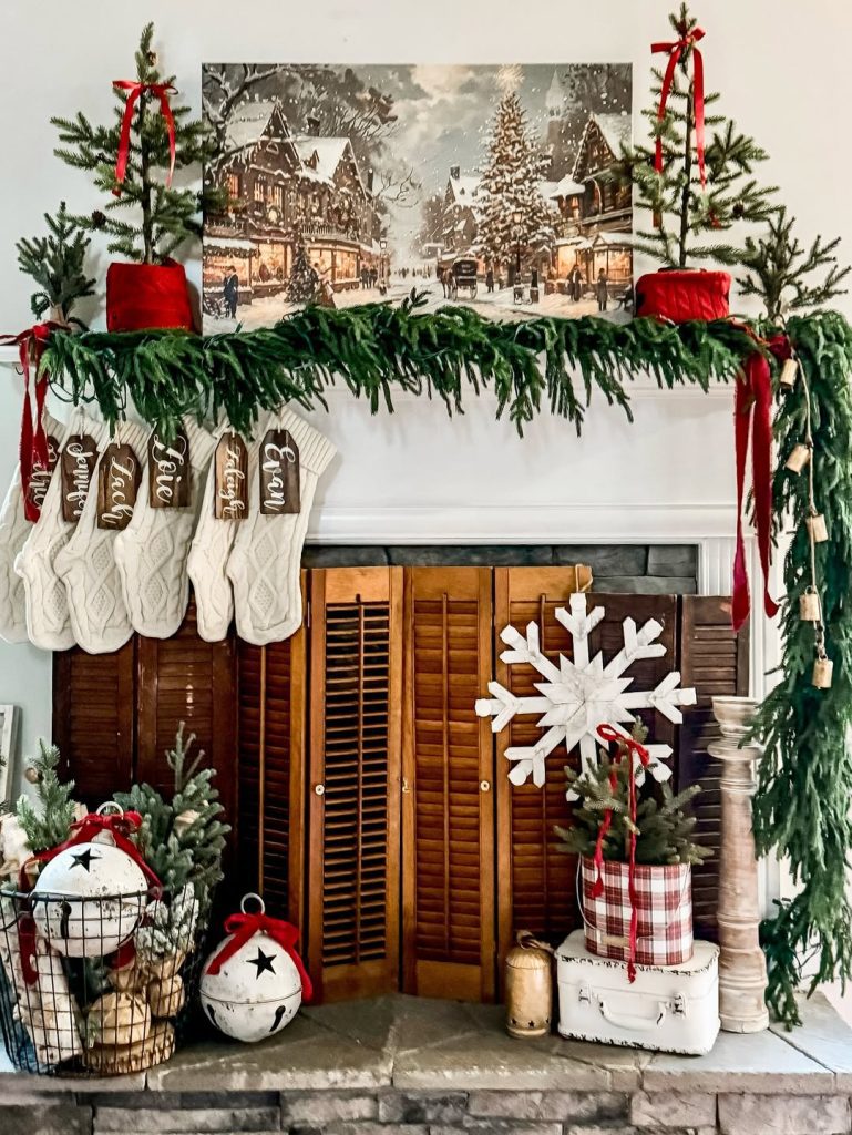 Traditional farmhouse mantel with winter artwork stockings and evergreen garland