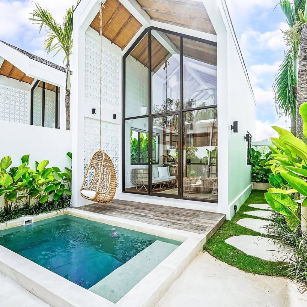 Small tropical pool with lush landscaping and glass doors