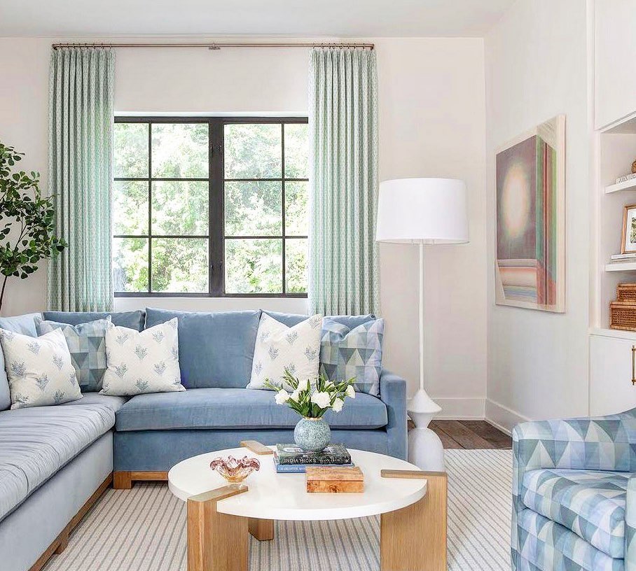 Light blue sectional sofa with round white coffee table