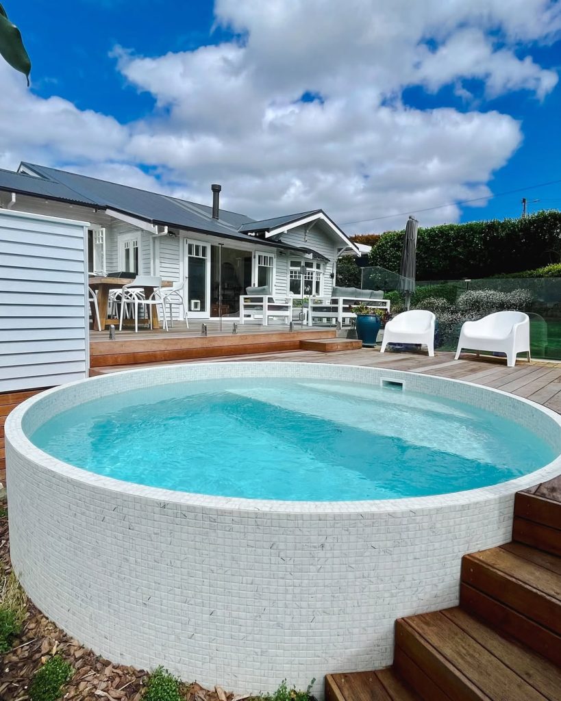Round elevated pool with wood decking and mosaic tile finish