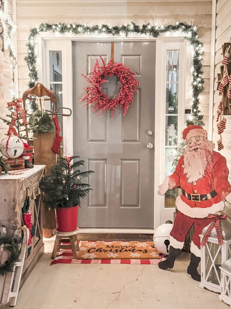 Christmas decorated front porch with wreath Santa figure garland