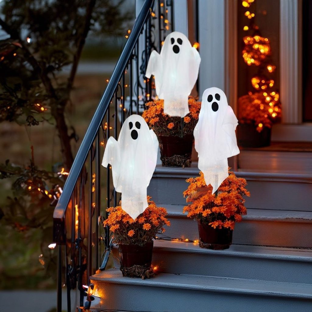 White ghost decorations in flower pots on front porch steps