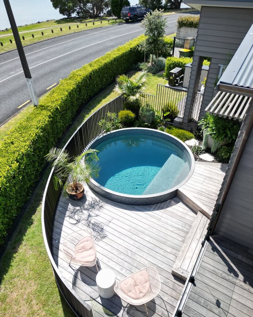 Round pool with curved wooden deck and modern outdoor seating