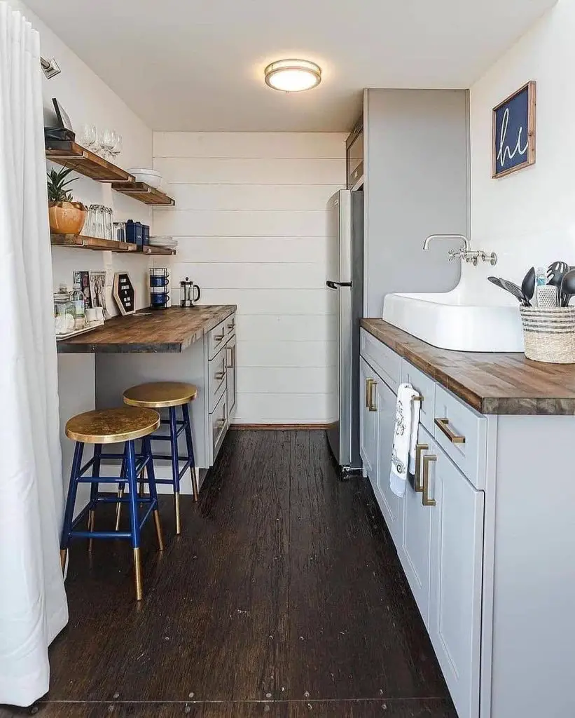 Narrow galley kitchen with white cabinets floating shelves wood counters