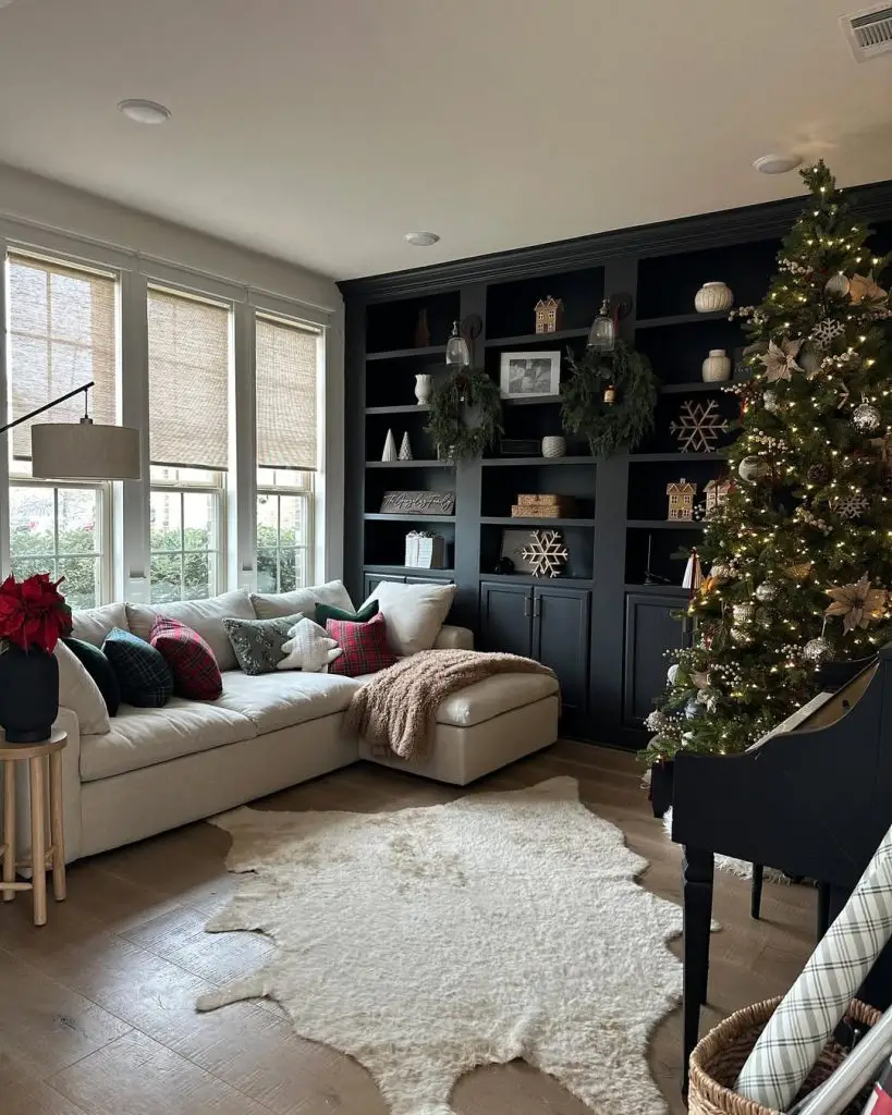 Modern living room with Christmas tree, dark built-ins, neutral sofa, and plaid accents.