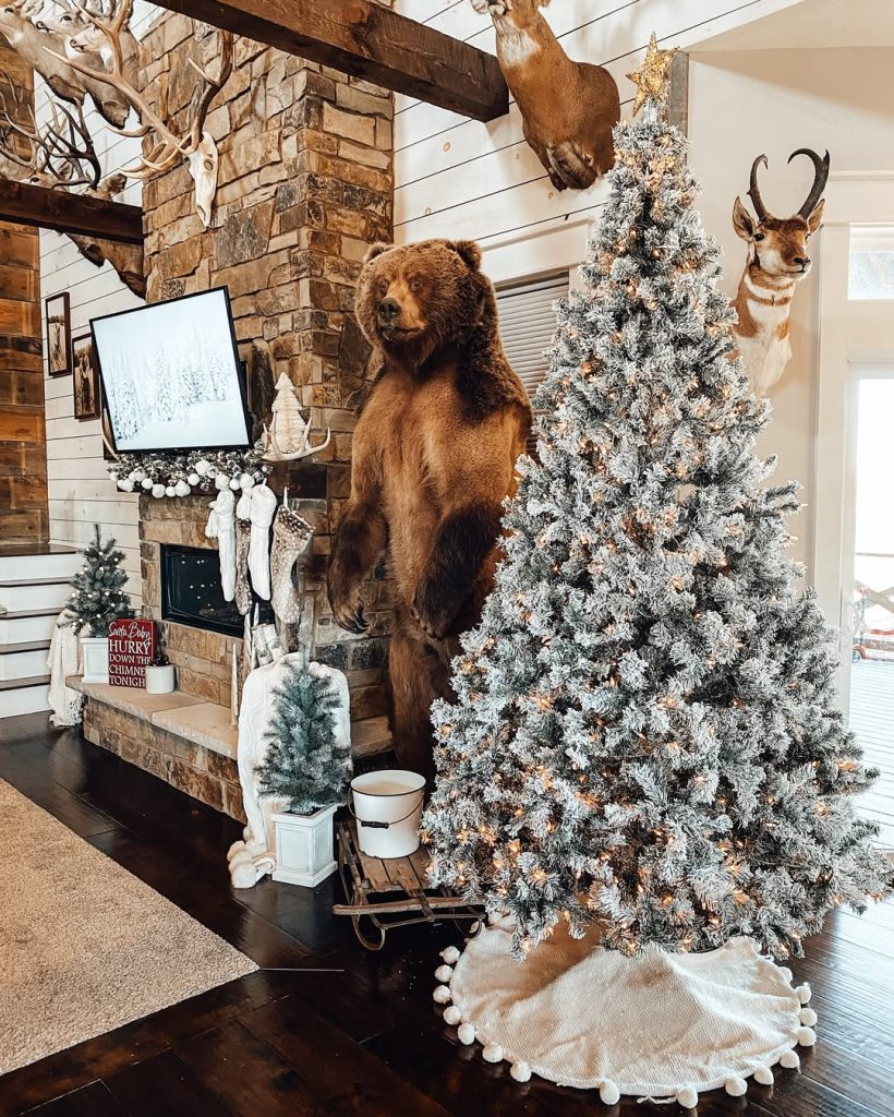 Mountain lodge Christmas decor with flocked tree and stone fireplace