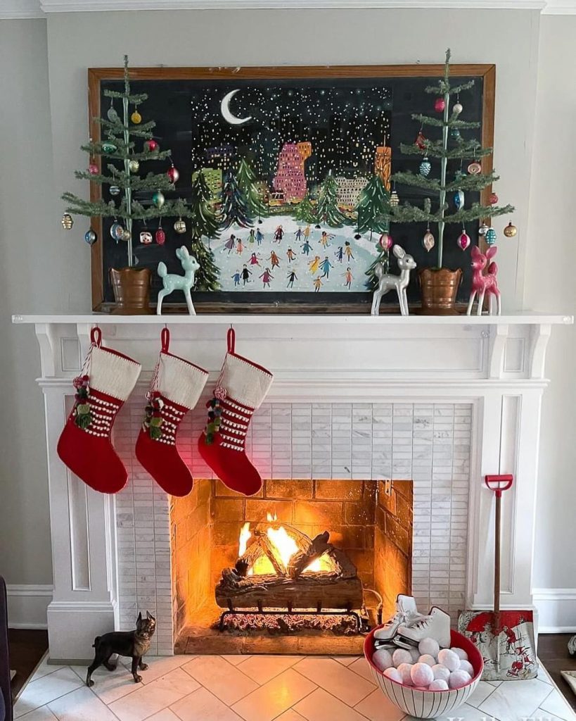 Fireplace mantel with chalkboard art potted trees and knitted Christmas stockings