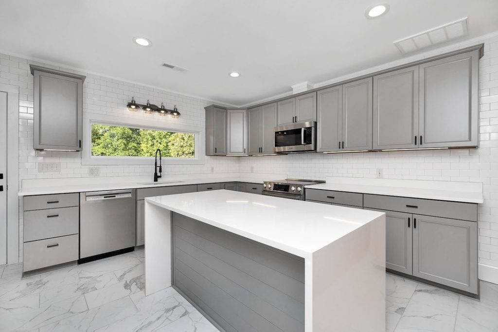 Modern gray kitchen with white island and subway tile backsplash