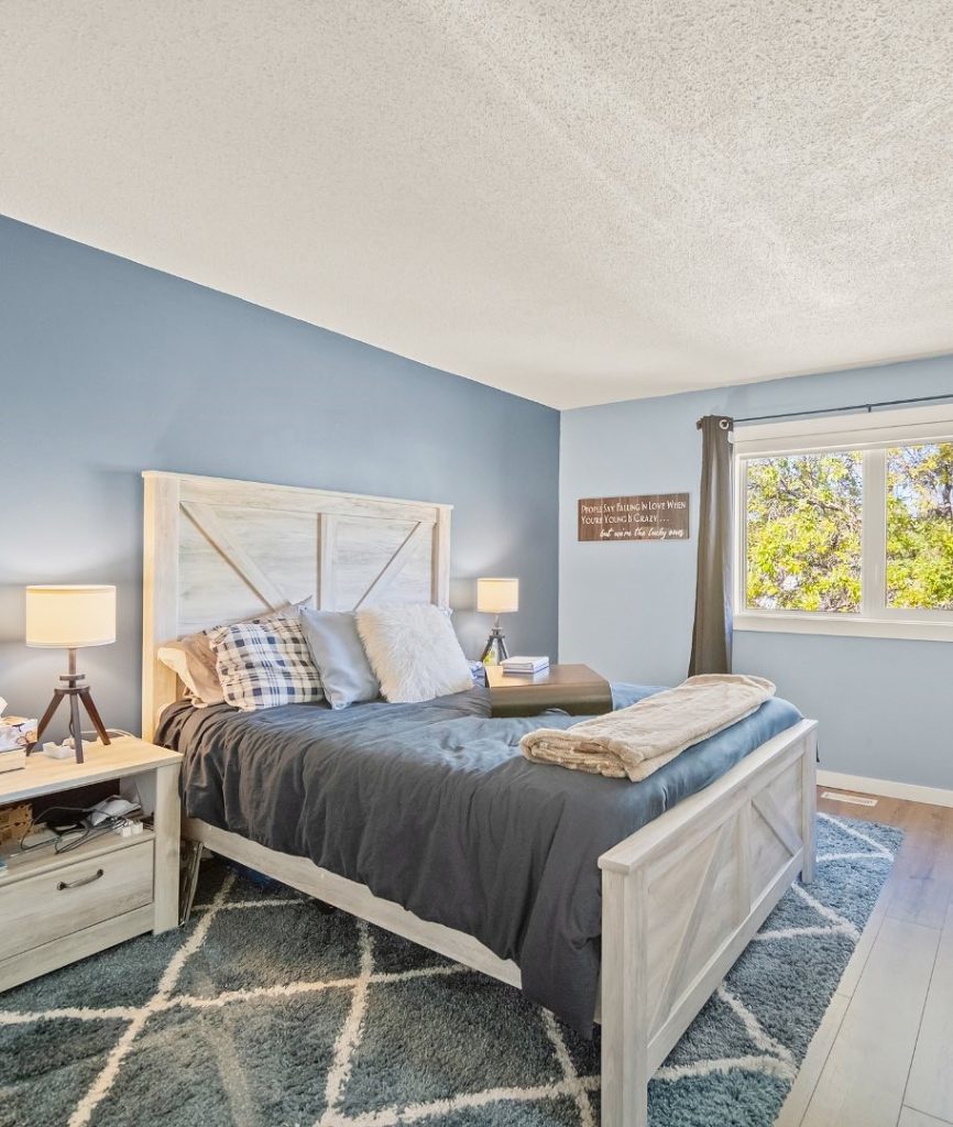 Rustic blue bedroom with white wooden furniture and plaid accents