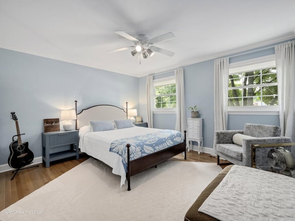 Modern blue bedroom with metal bed frame and musical instruments