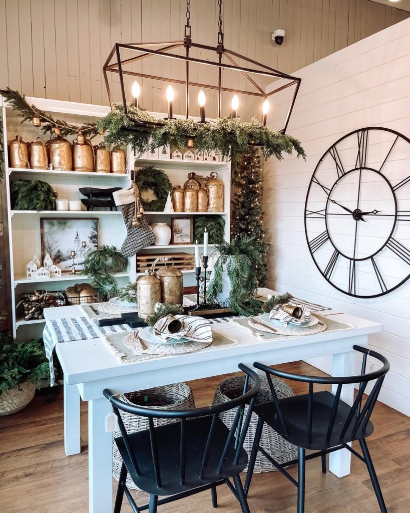 Dining room with geometric chandelier evergreen garland shelving