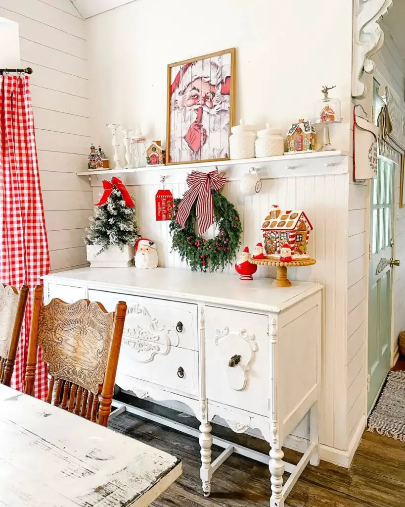 White kitchen with flocked Christmas tree, red gingham curtains, holiday sideboard, country decorations