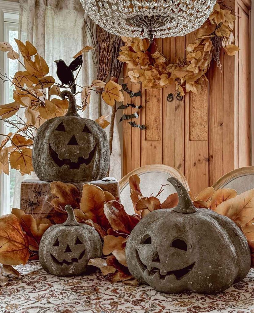 Vintage pumpkin display with autumn leaves crow crystal chandelier rustic setting