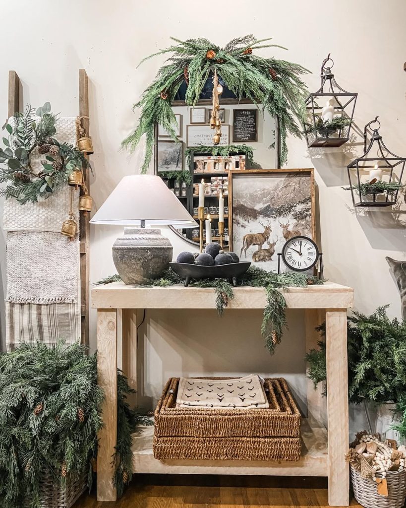 Console table with Christmas greenery lanterns and artwork