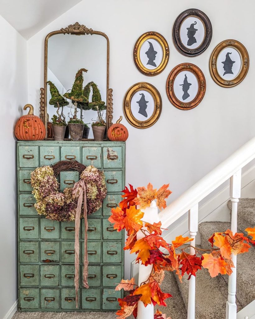 Hallway witch silhouette gallery wall vintage cabinet autumn wreath staircase
