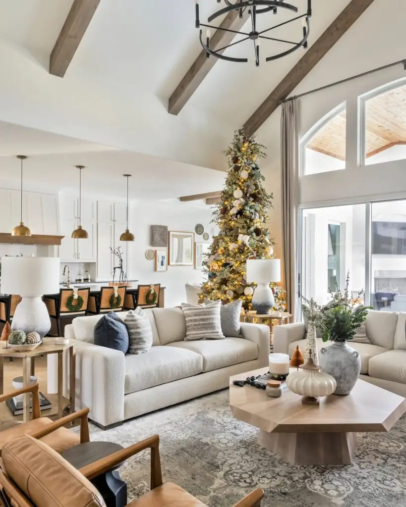 Open concept living room with Christmas tree, exposed beams, and modern furniture.