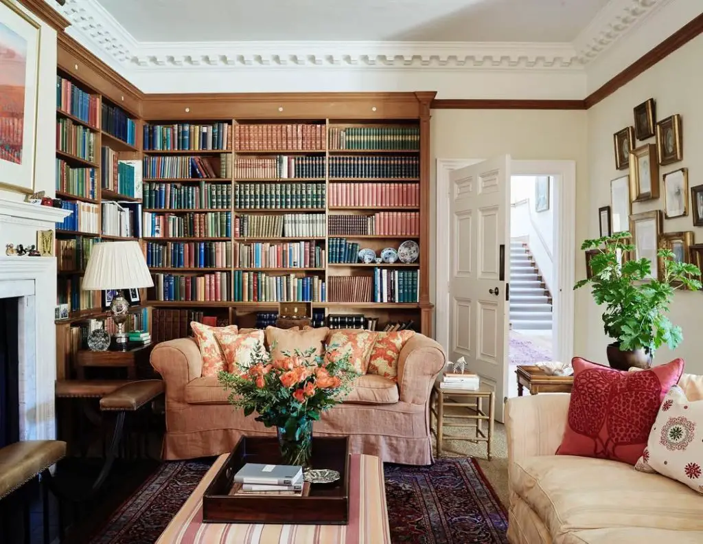 Traditional library room with built-in bookshelves and tan sofa
