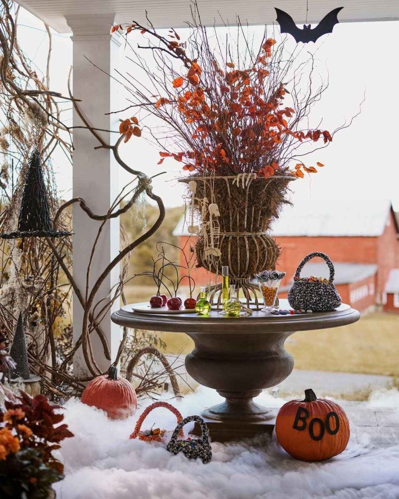 Indoor Halloween table centerpiece with branches pumpkins